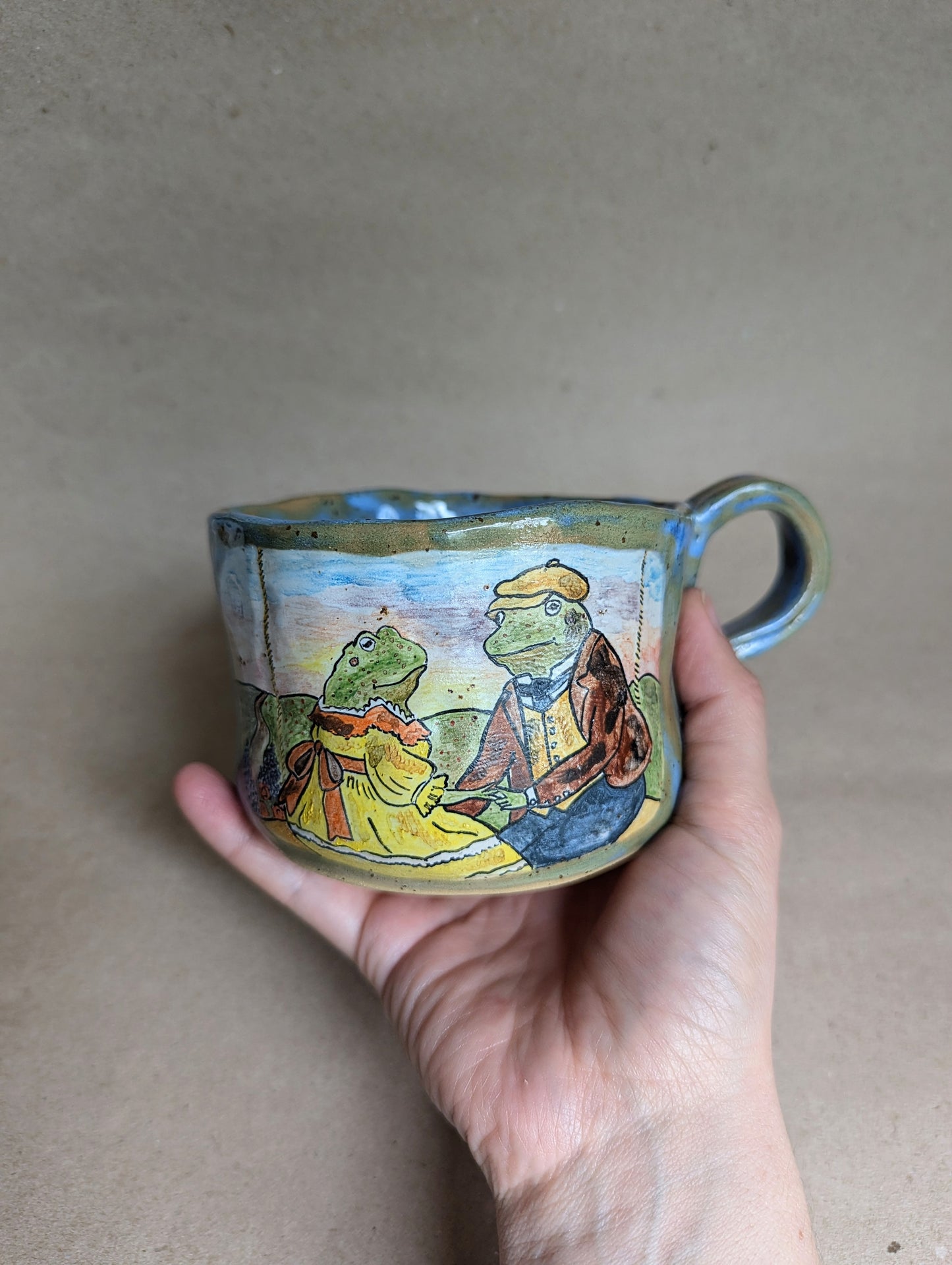 Handmade ceramic mug with frogs in love